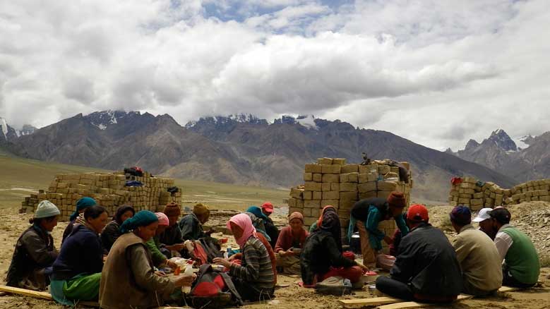 Kumik villagers taking a lunch break while building a solar-heated community center. Photo by Jonathan Mingle, Fire and Ice.