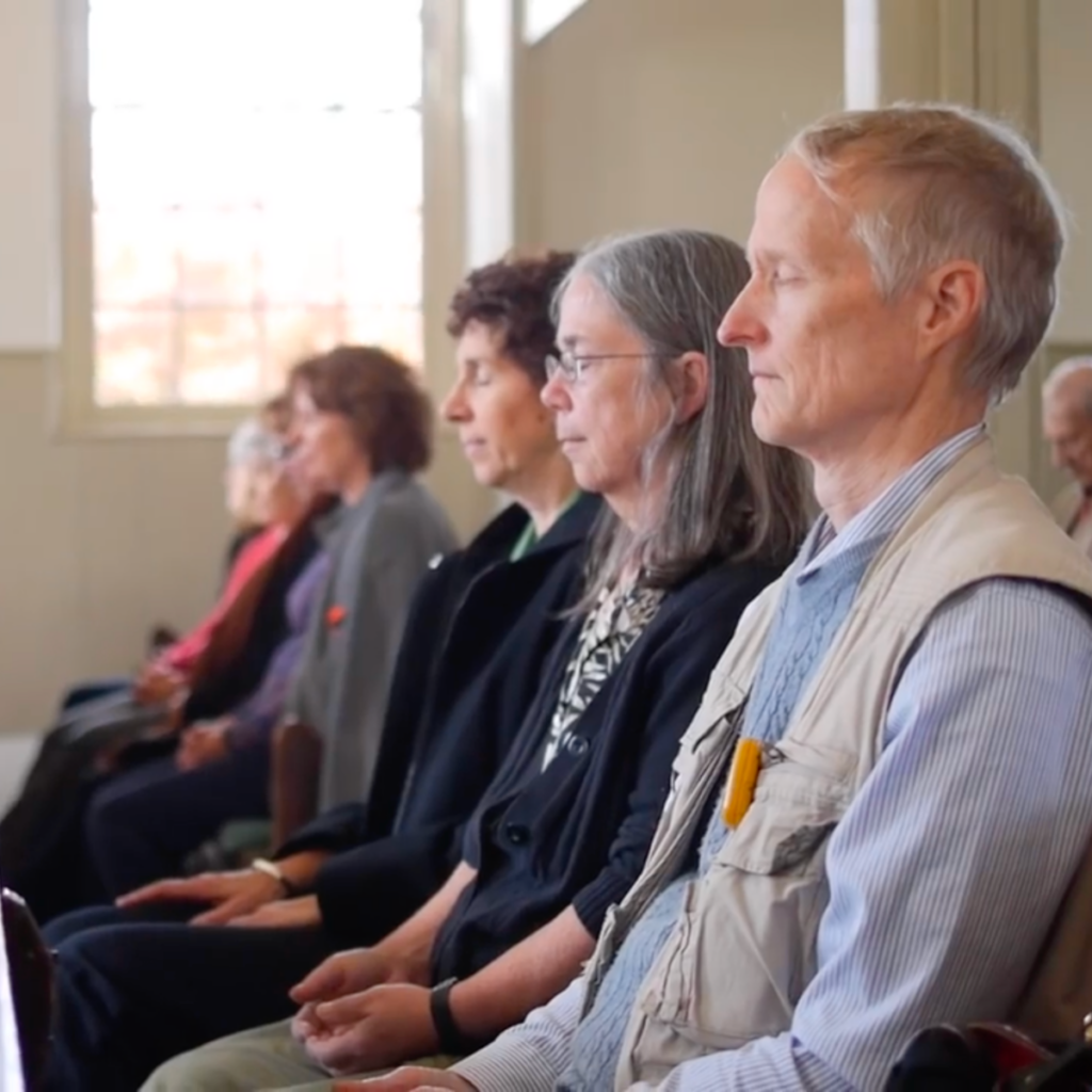 A row of Friends sitting in silent worship at meeting.